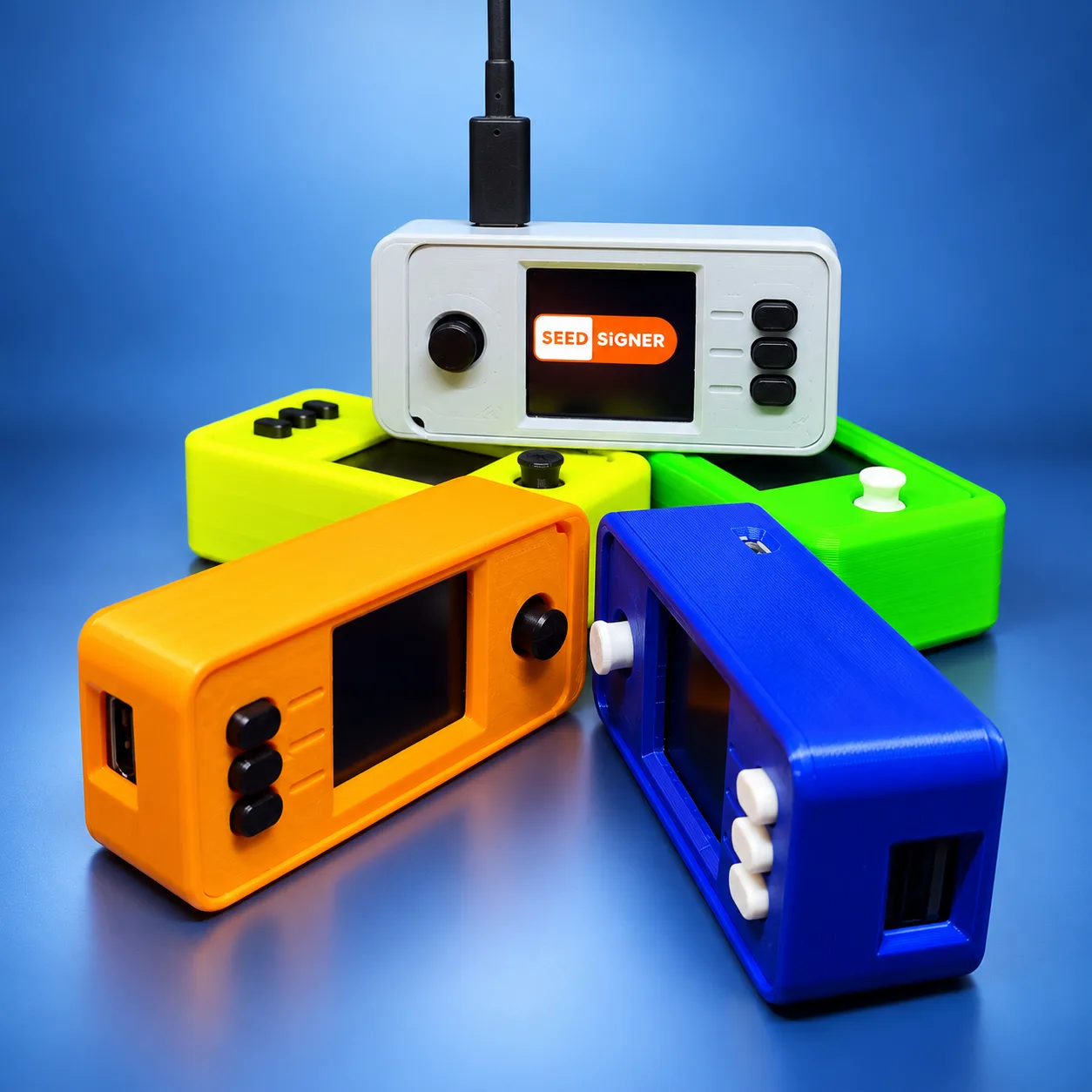 SeedSigner devices in white, yellow, green, orange and blue cases