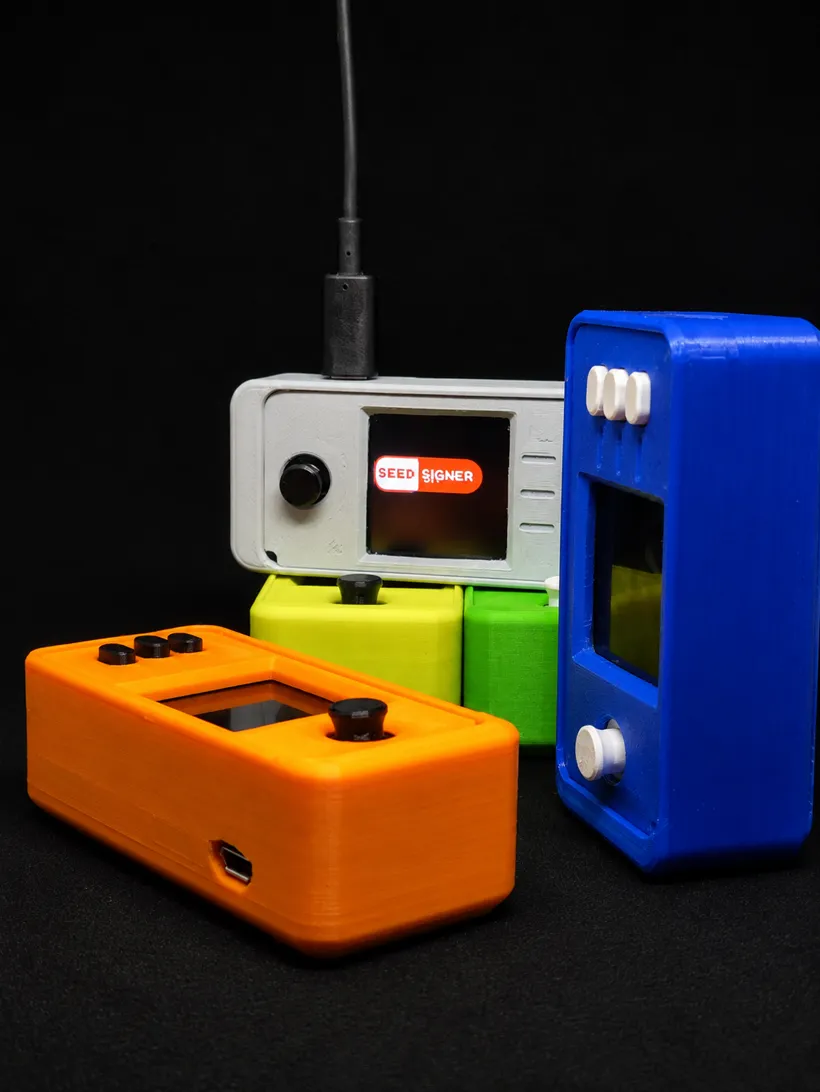 SeedSigner devices in orange, green, blue and white cases